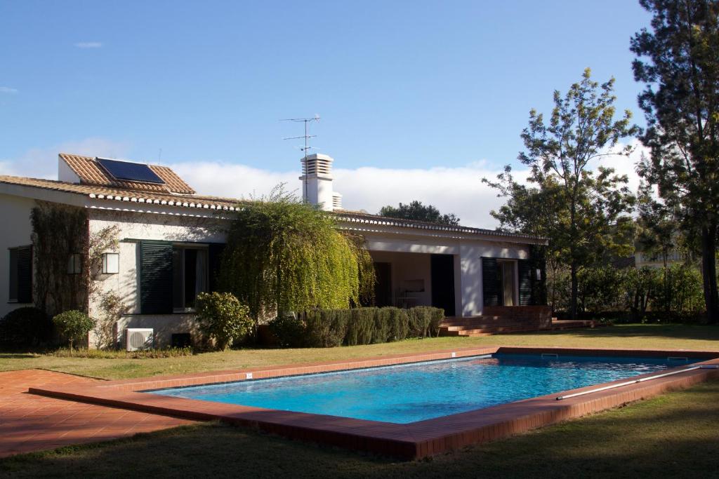 una piscina frente a una casa en Penina Family House, en Portimão