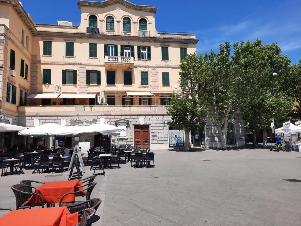 dziedziniec ze stołami i krzesłami przed budynkiem w obiekcie Sun&SeaGuestHouse Lido di Roma w mieście Lido di Ostia