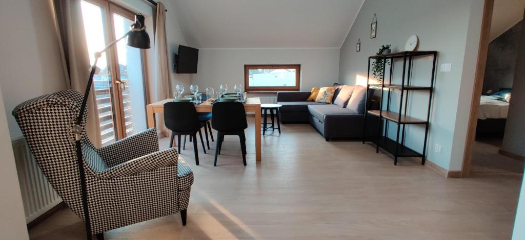 ein Wohnzimmer mit einem Sofa, einem Tisch und Stühlen in der Unterkunft 4 Kąty Apartamenty Koronowo in Koronowo