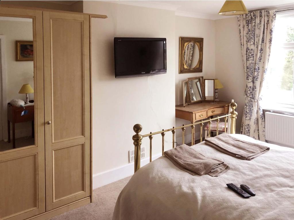 a bedroom with a bed with a television on the wall at Residential 3 bed house Harnham in Salisbury