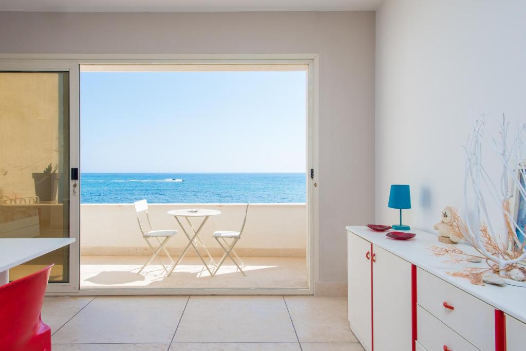 una cocina con una puerta que conduce al océano en Beach Studios con accesso diretto alla spiaggia, en Torre Pali