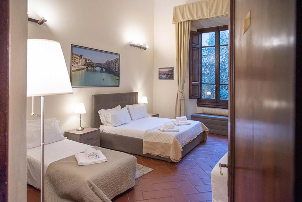 a hotel room with two beds and a window at Coco Places Soggiorno Panerai, Centro Storico in Florence