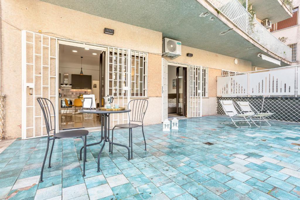 un patio con sillas y una mesa en el suelo de baldosa en Vomero Deluxe Apartments en Nápoles