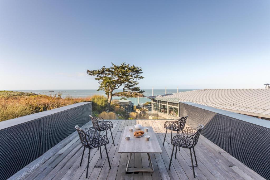 un patio con sillas y una mesa en una terraza en Résidence Premium Le Bénétin- Saint Malo, en Saint-Malo