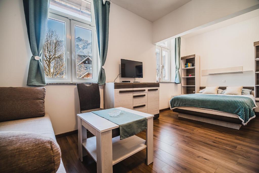 a small living room with a bed and a table at Studio CENTER in Zgornje Jezersko