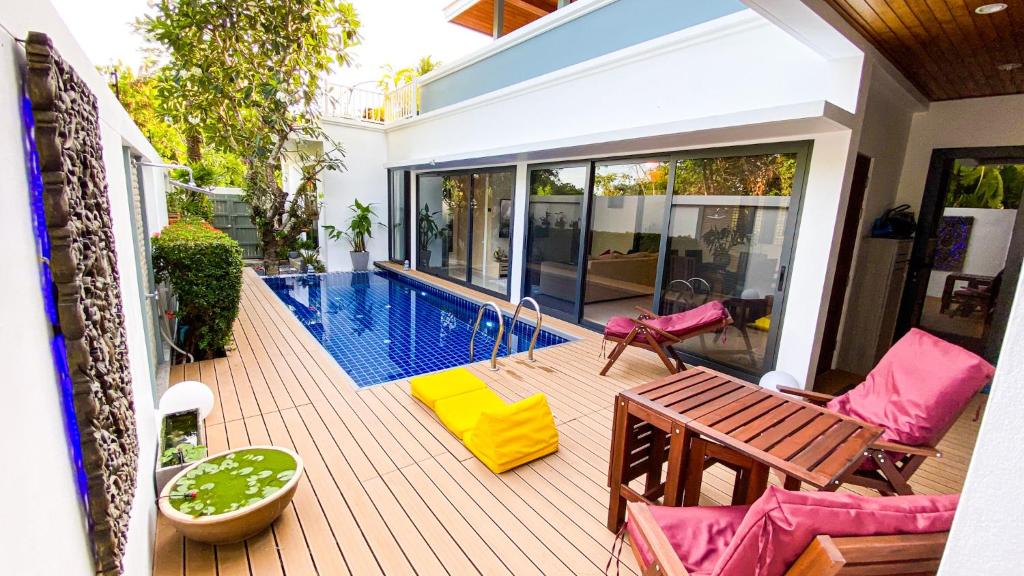 a patio with chairs and a swimming pool at Villa Soi Mangosteen in Rawai Beach