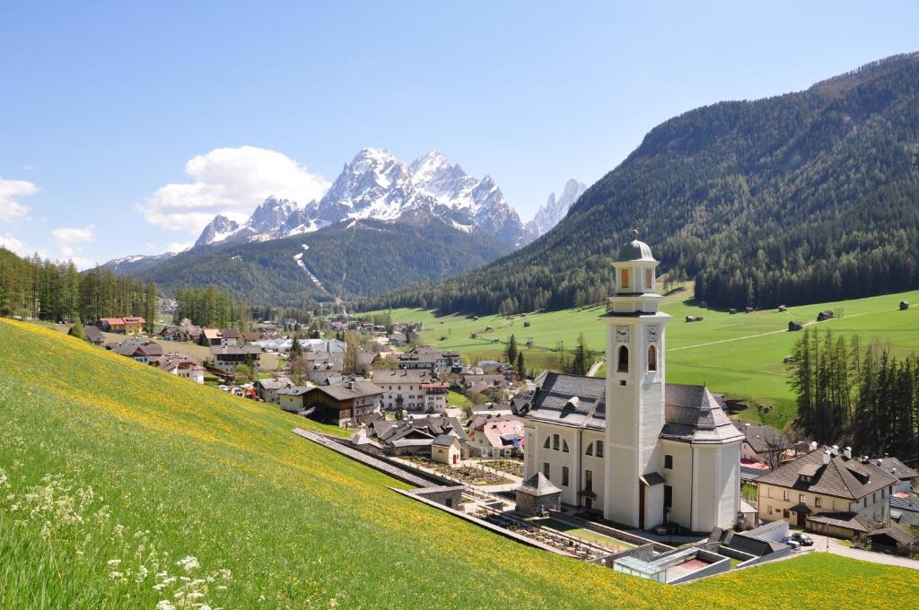 a small town with a church in the mountains at Aurturist Sesto in Sesto