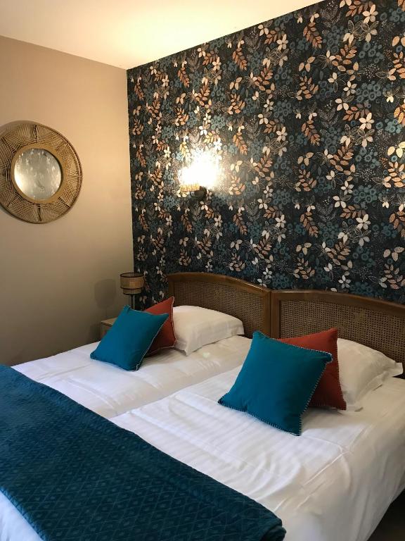 - une chambre avec 2 lits dotés d'oreillers bleus et rouges dans l'établissement La petite auberge, à Villefranche-du-Périgord