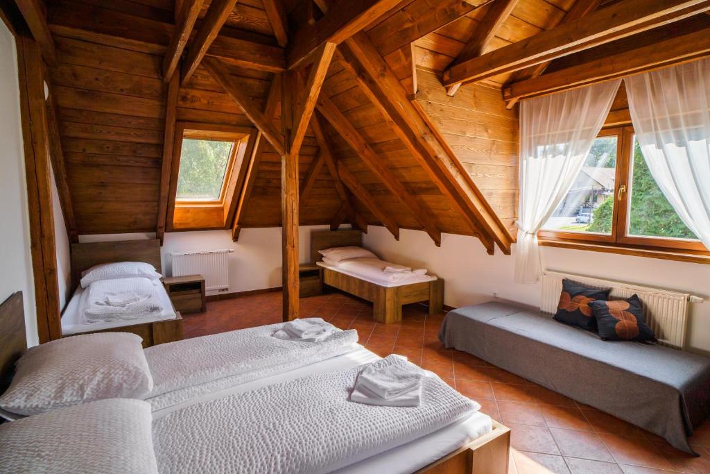 een slaapkamer met 2 bedden in een houten huis bij Penzion Bílek in Chotěboř