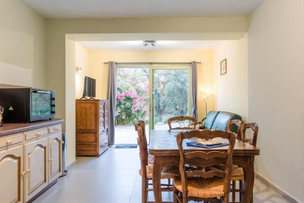 a dining room with a table and chairs and a television at Appartement dans maison chaleureuse in Olmeto