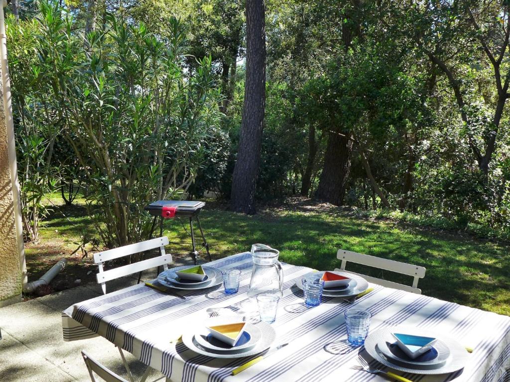 - une table de pique-nique avec des assiettes et des verres dans l'établissement Holiday Home Golf de l'Ardilouse by Interhome, à Lacanau-Océan