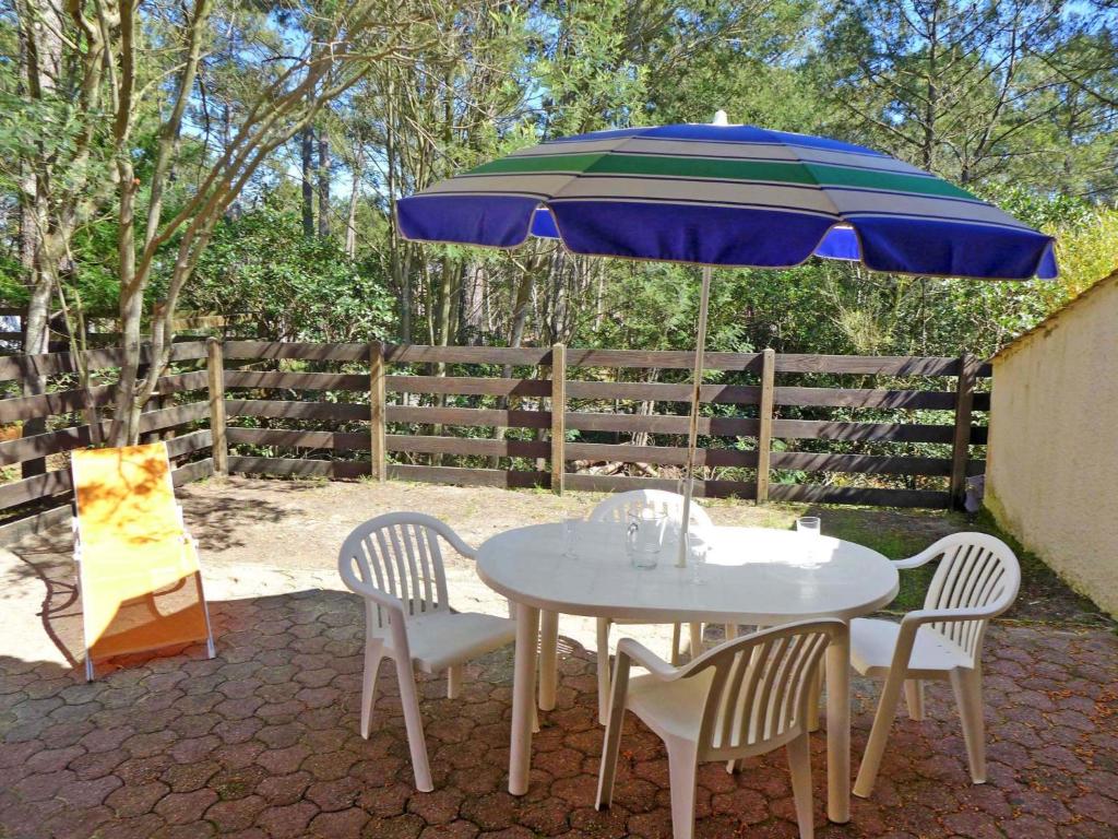 ラカノー・オセアンにあるHoliday Home Les As-10 by Interhomeの青い傘下のテーブルと椅子
