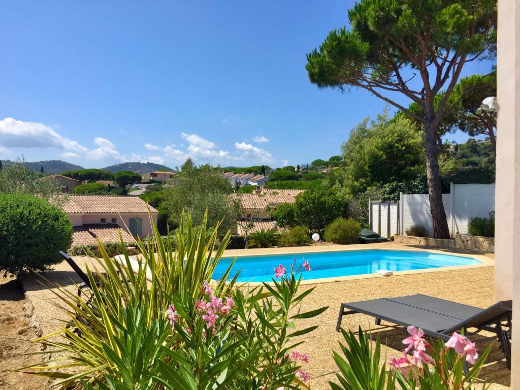 a swimming pool in a yard with a picnic table and flowers at Holiday Home Le Mas d'Esquières 7 by Interhome in Les Issambres