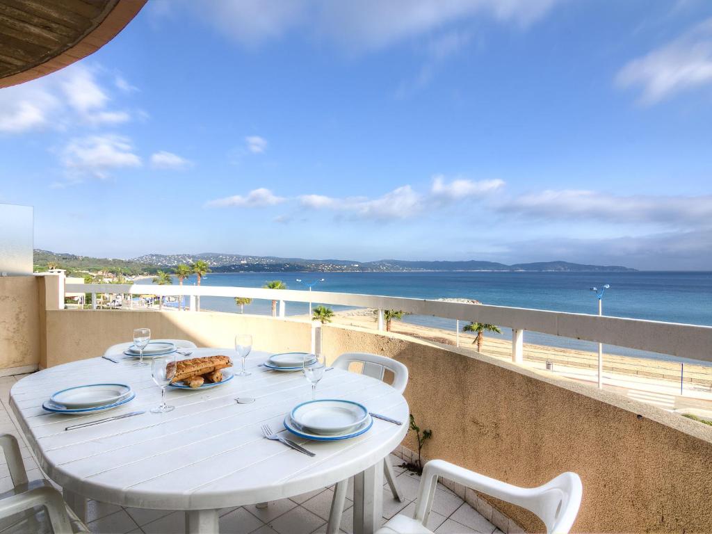 a white table on a balcony with a view of the ocean at Apartment Le Palazzo del Mar-6 by Interhome in Cavalaire-sur-Mer