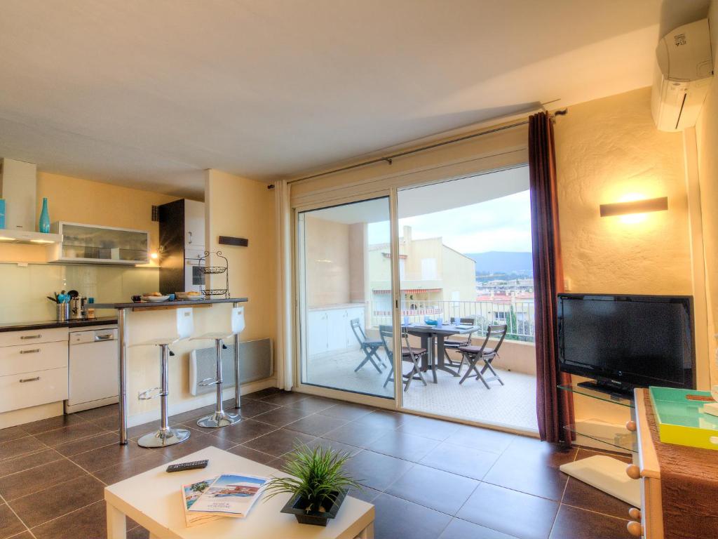 a kitchen and a living room with a large sliding glass door at Apartment Porto di Mar-5 by Interhome in Cavalaire-sur-Mer