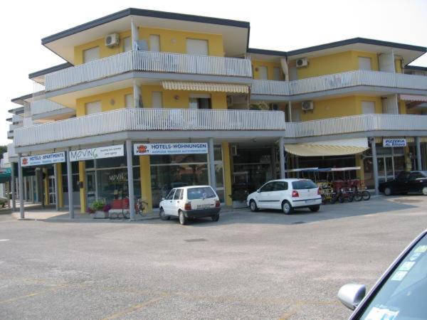 two cars parked in a parking lot in front of a building at Condominio Canaima in Bibione