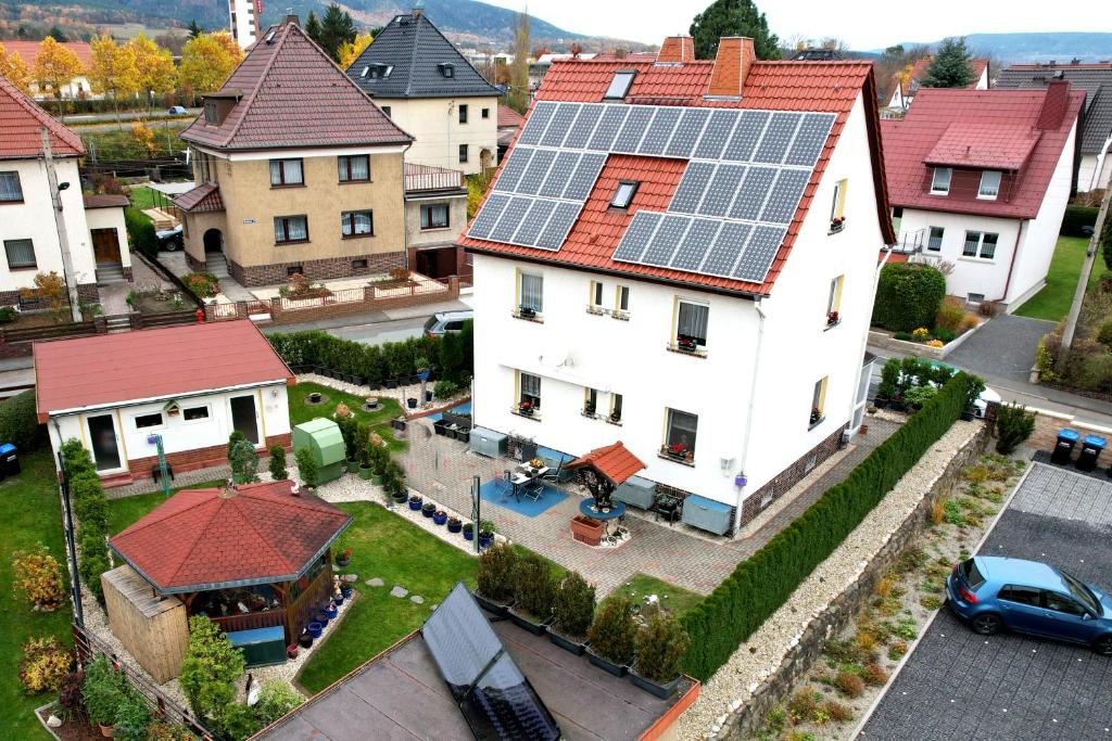 ein großes weißes Haus mit Sonnenkollektoren auf dem Dach in der Unterkunft Ferienwohnung Weidler 1 in Saalfeld