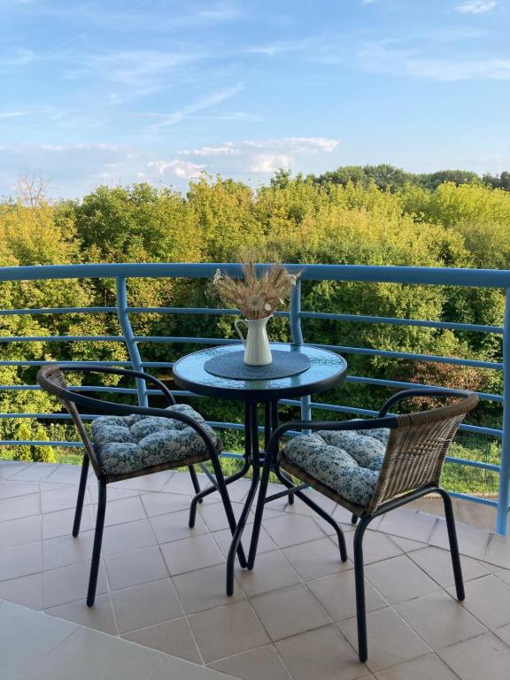 a table and two chairs on a balcony at Libellula Apartman Hévíz in Hévíz