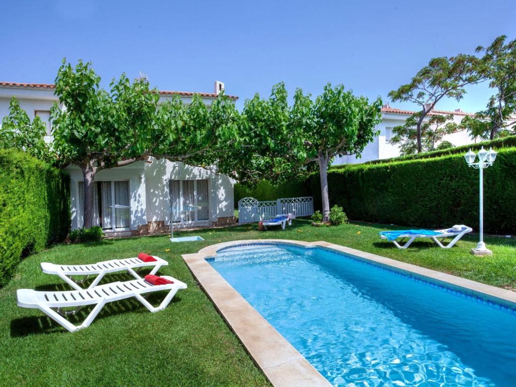 une arrière-cour avec une piscine dotée de 2 chaises longues et d'une piscine dans l'établissement Holiday Home Montalt VI by Interhome, à Miami Platja