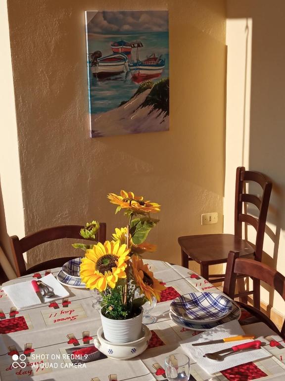 a table with a vase of flowers on top of it at Residence Poseidon in Lido Marini