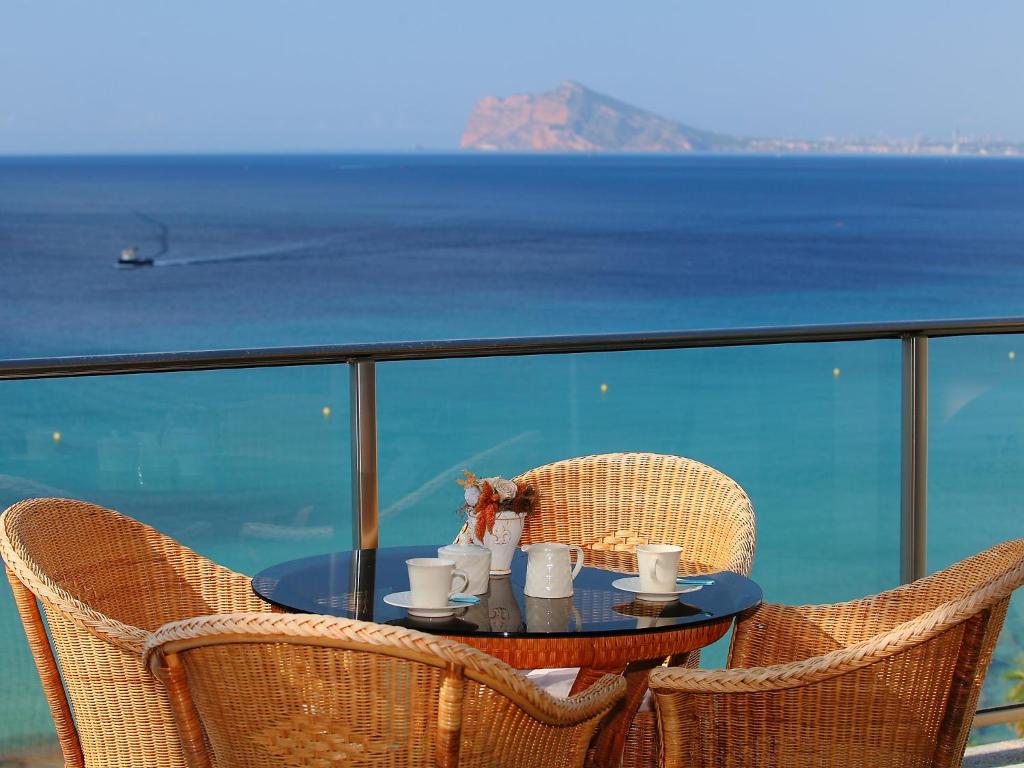 a table with cups and mugs on top of a balcony at Apartment Sotavento by Interhome in Calpe