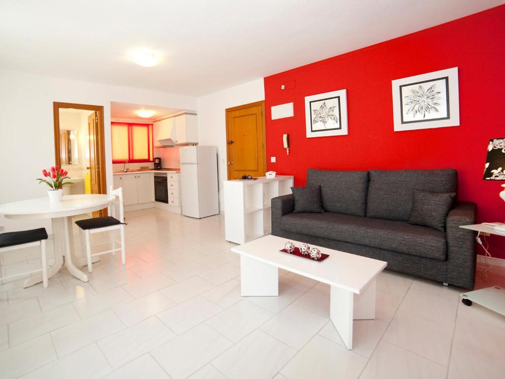 een woonkamer met een bank en een rode muur bij Studio Apolo VI-4 by Interhome in Calpe