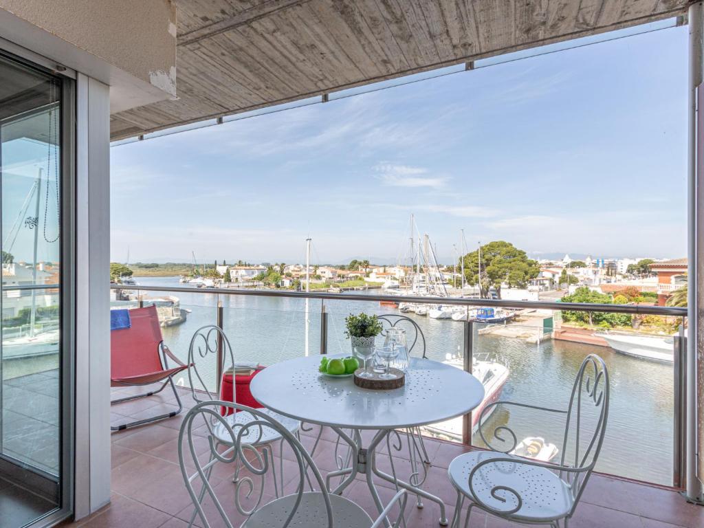 a table and chairs on a balcony with a view of the water at Apartment Cap Mestral by Interhome in Roses