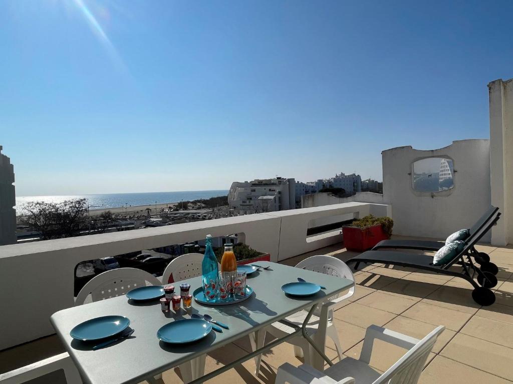 a table and chairs on a balcony with a view of the ocean at Apartment Jardins d'Ulysse II by Interhome in La Grande Motte