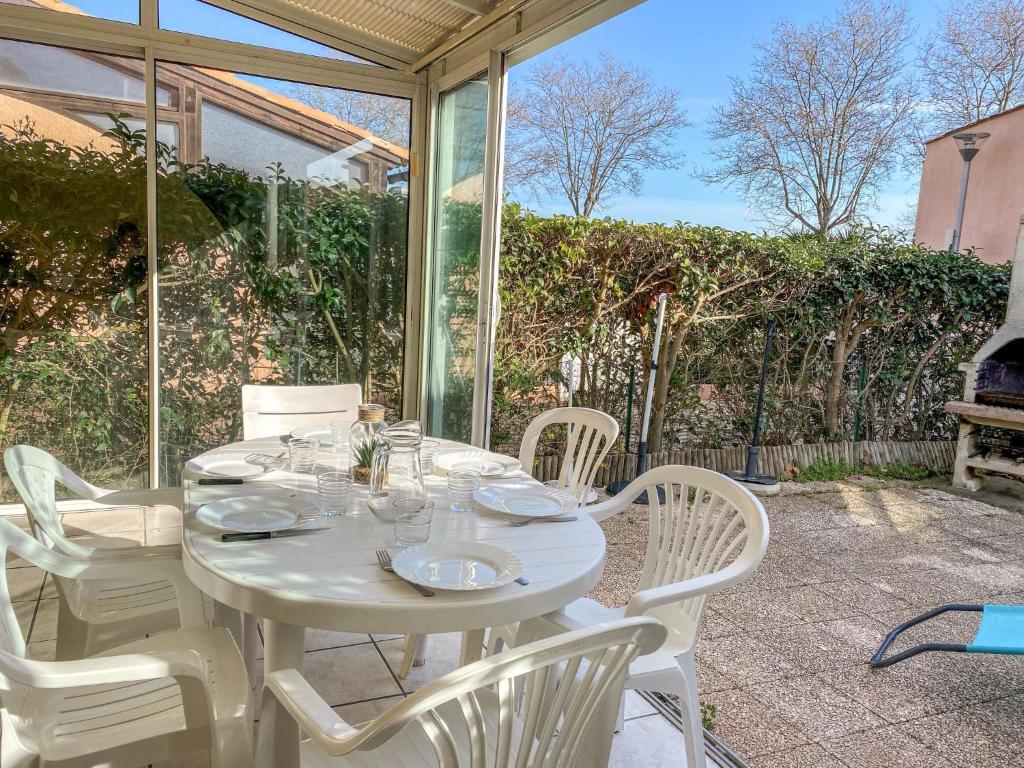 a white table and chairs on a patio at Holiday Home Les Maisons du Golf by Interhome in Cap d'Agde