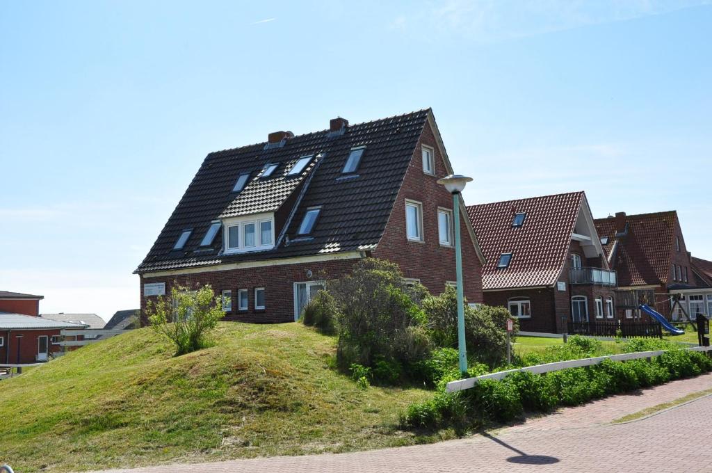 uma casa grande no topo de uma colina em Ferienhaus Nordstrand Whg 4 em Baltrum