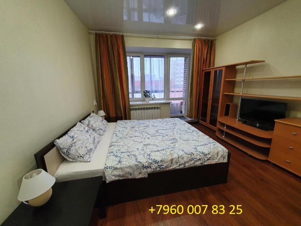 アルハンゲリスクにあるVoskresenskaya 55のベッドルーム1室(ベッド1台付)、テレビが備わります。