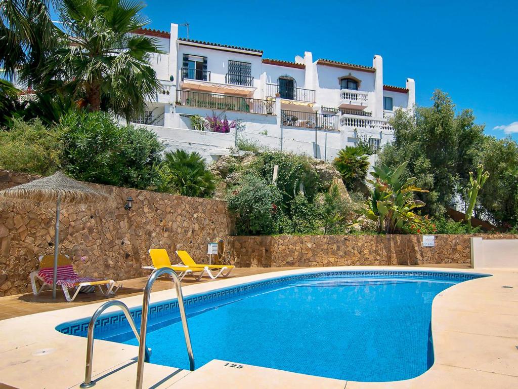 a swimming pool in front of a building at Holiday Home Tejon by Interhome in Nerja