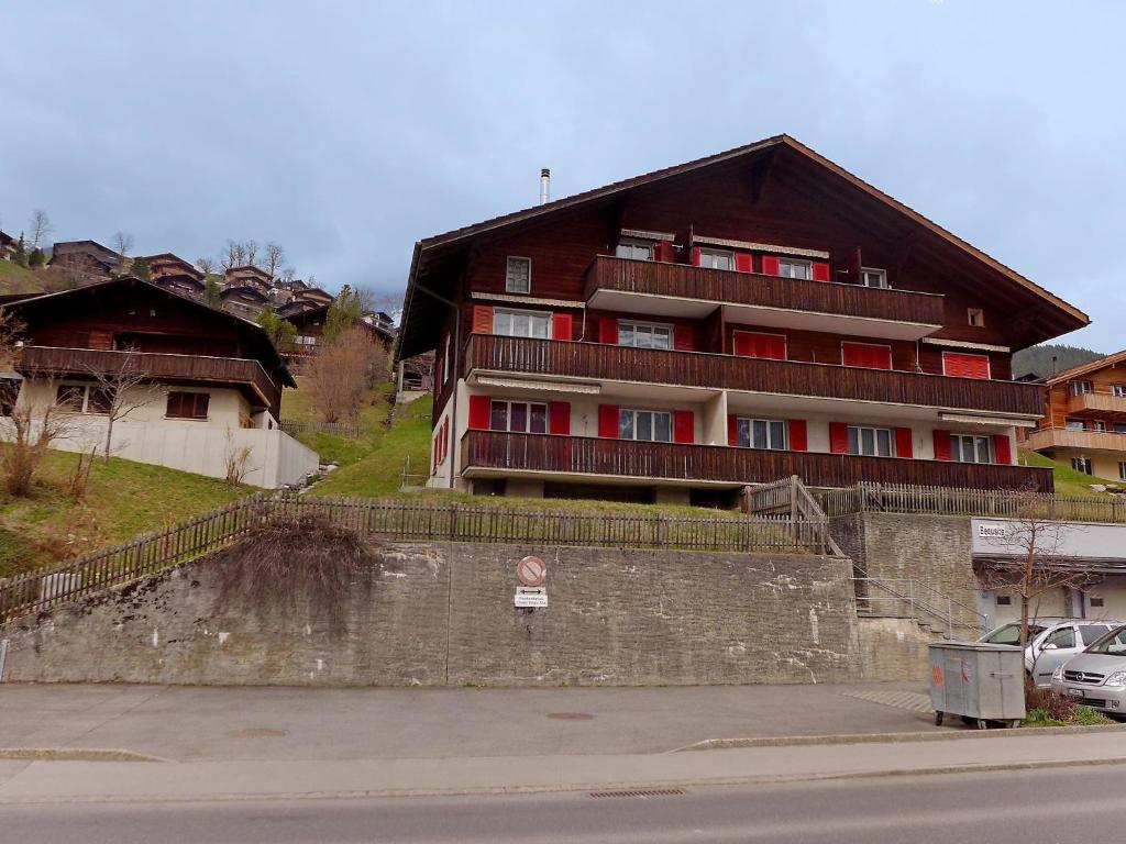 a large building with red doors on a hill at Apartment Chalet Beausite by Interhome in Grindelwald