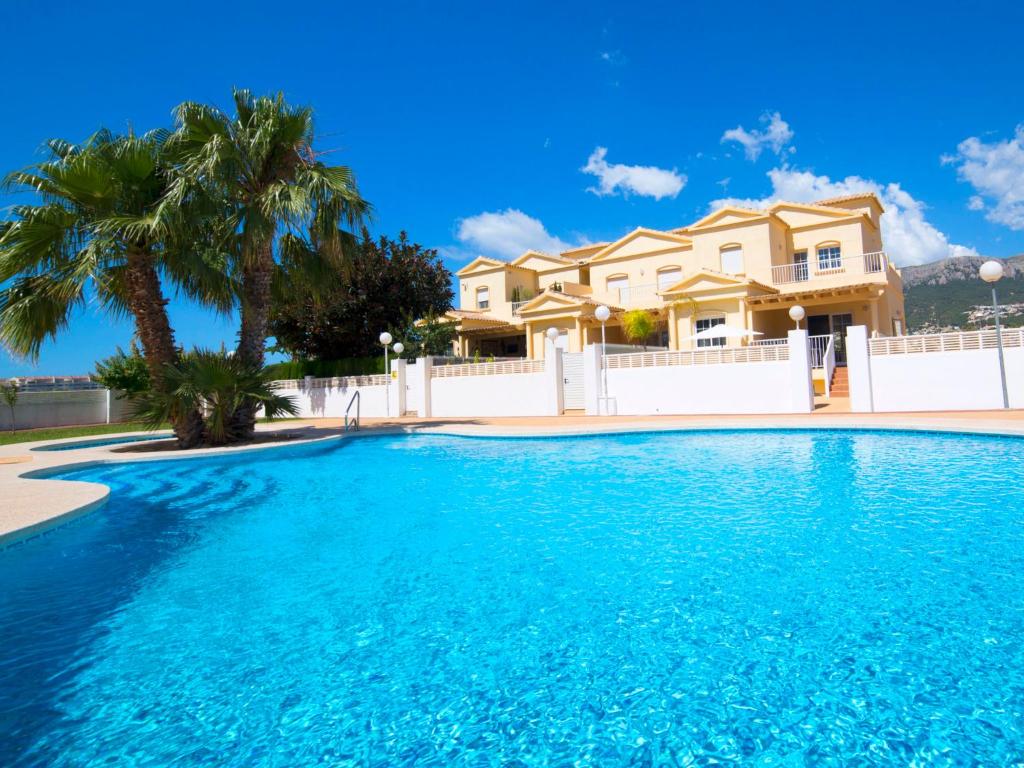 ein großer Pool vor einem Haus mit Palmen in der Unterkunft Holiday Home Luz del Sol by Interhome in Calpe
