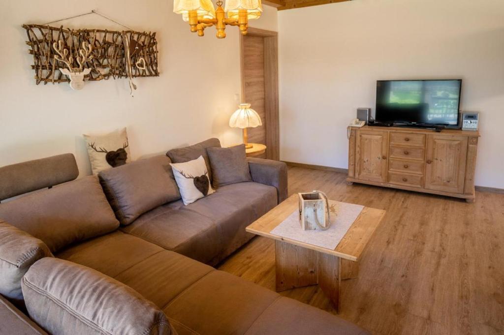 a living room with a couch and a tv at Landhaus Laih in Grafenau