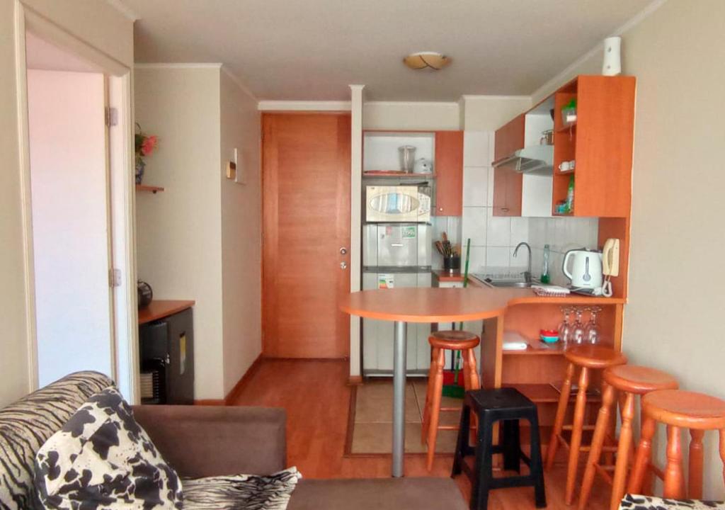 ein Wohnzimmer mit einem Tisch und einer Küche in der Unterkunft Santiago Centro in Santiago