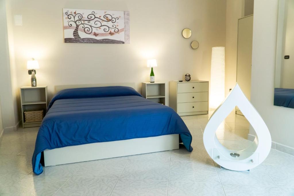 a bedroom with a blue bed and a mirror at A Casa di Nonna Ada in Manduria