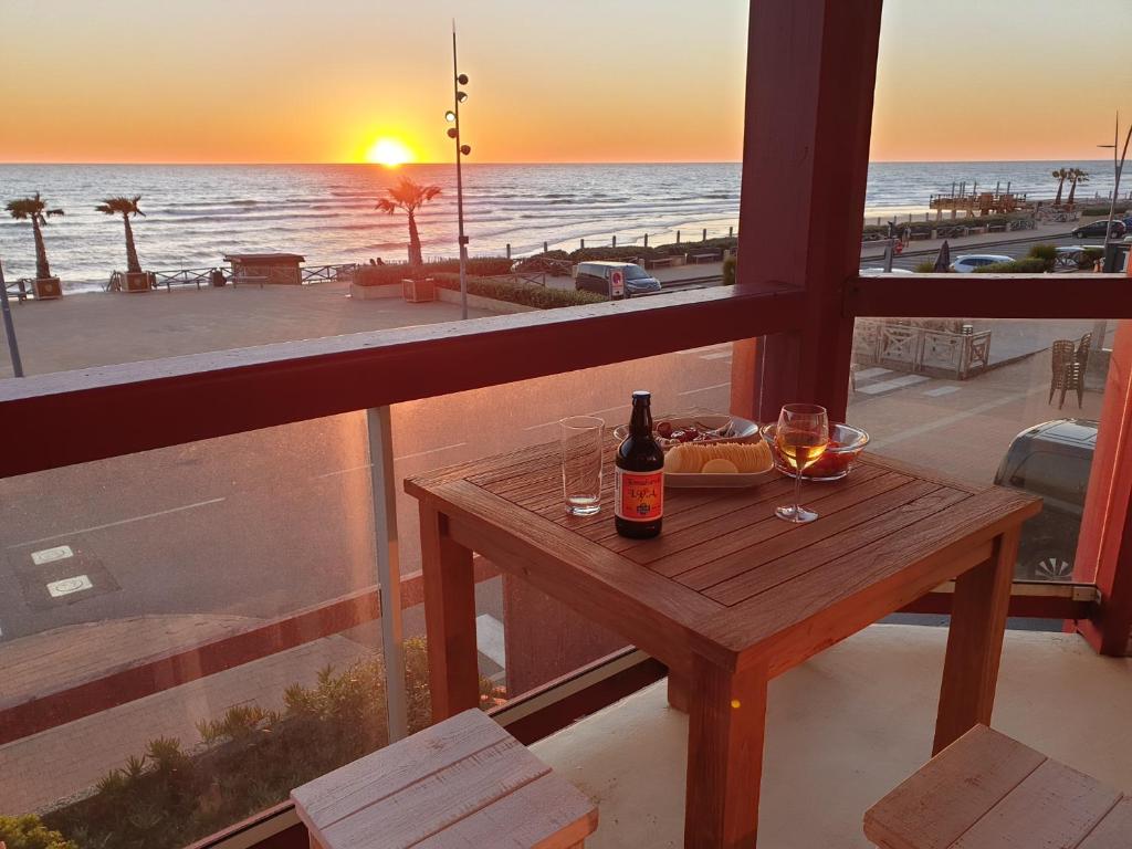 una mesa con una botella de vino y un tazón de comida en Appartement Front de mer - Vue Ocean en Lacanau-Océan