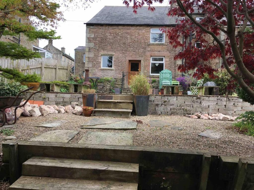 a house with a stone wall and stairs in front of it at Beautiful 2-Bed Cottage in Hurst Green in Clitheroe