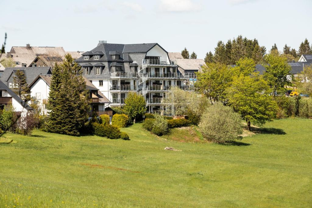 a large apartment building on a green lawn at Astenblick Apartments in Winterberg