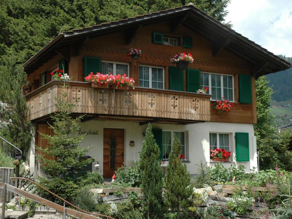 a house in the mountains with flowers on the balcony at Apartment Bärgchutzli 1- Stock by Interhome in Adelboden
