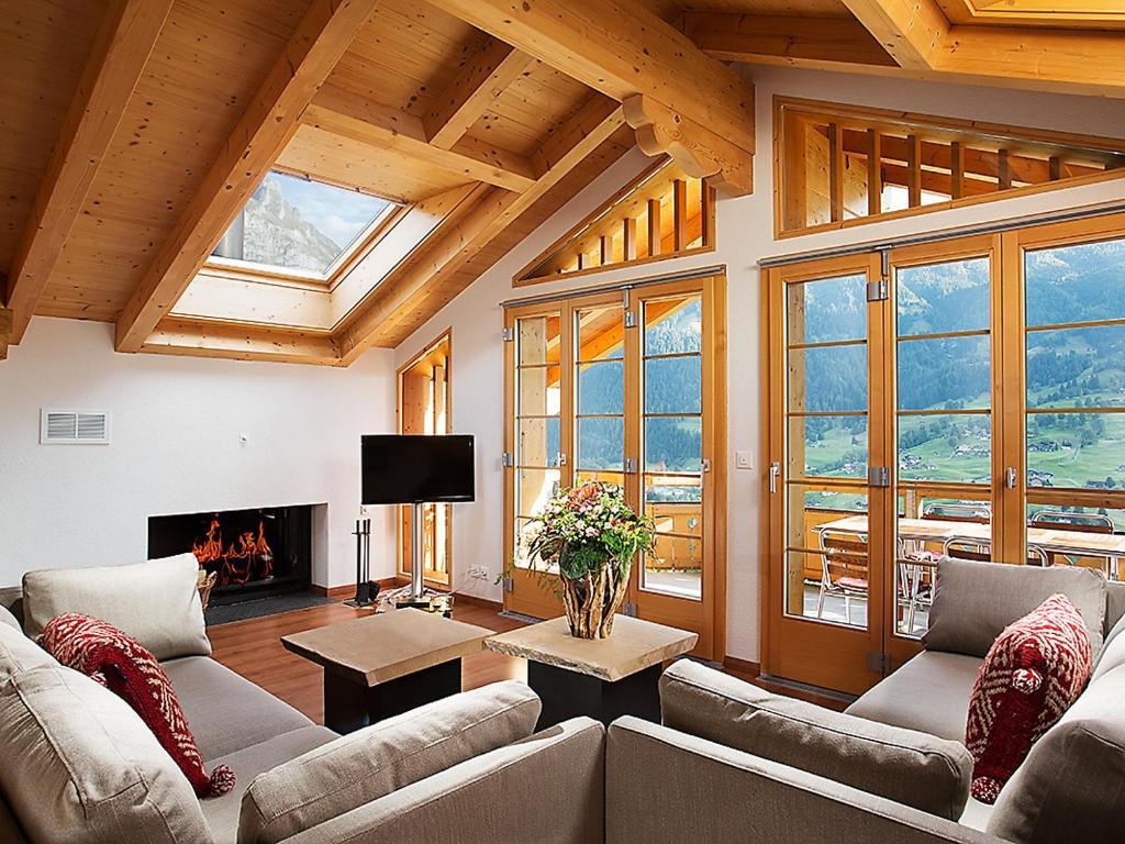 ein Wohnzimmer mit einem Sofa und einem Kamin in der Unterkunft Apartment Chalet Tuftstein by Interhome in Grindelwald