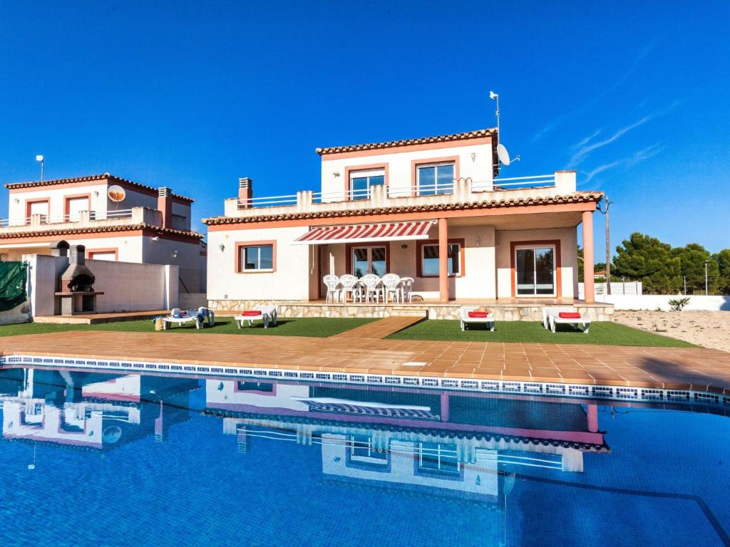 a villa with a swimming pool in front of a house at Villa Villa Malva I by Interhome in Les tres Cales