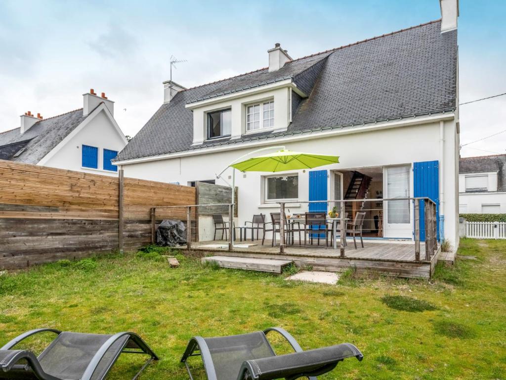 une maison avec une terrasse dotée de chaises et d'un parasol dans l'établissement Holiday Home Penthievre by Interhome, à Légenès