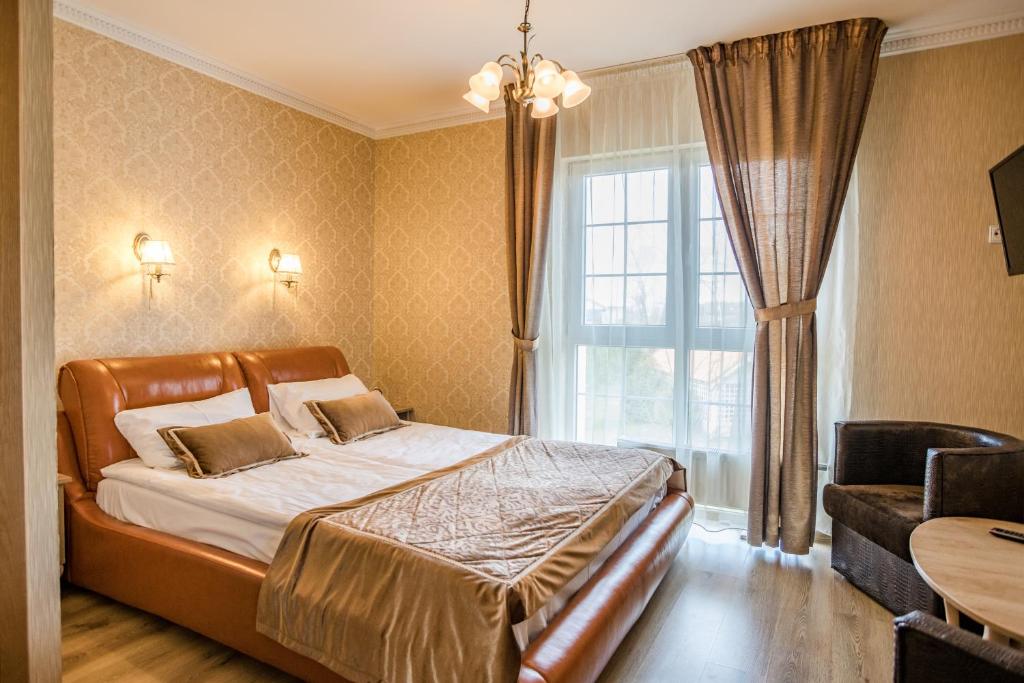 um quarto com uma cama grande e uma janela em Župė em Radailiai
