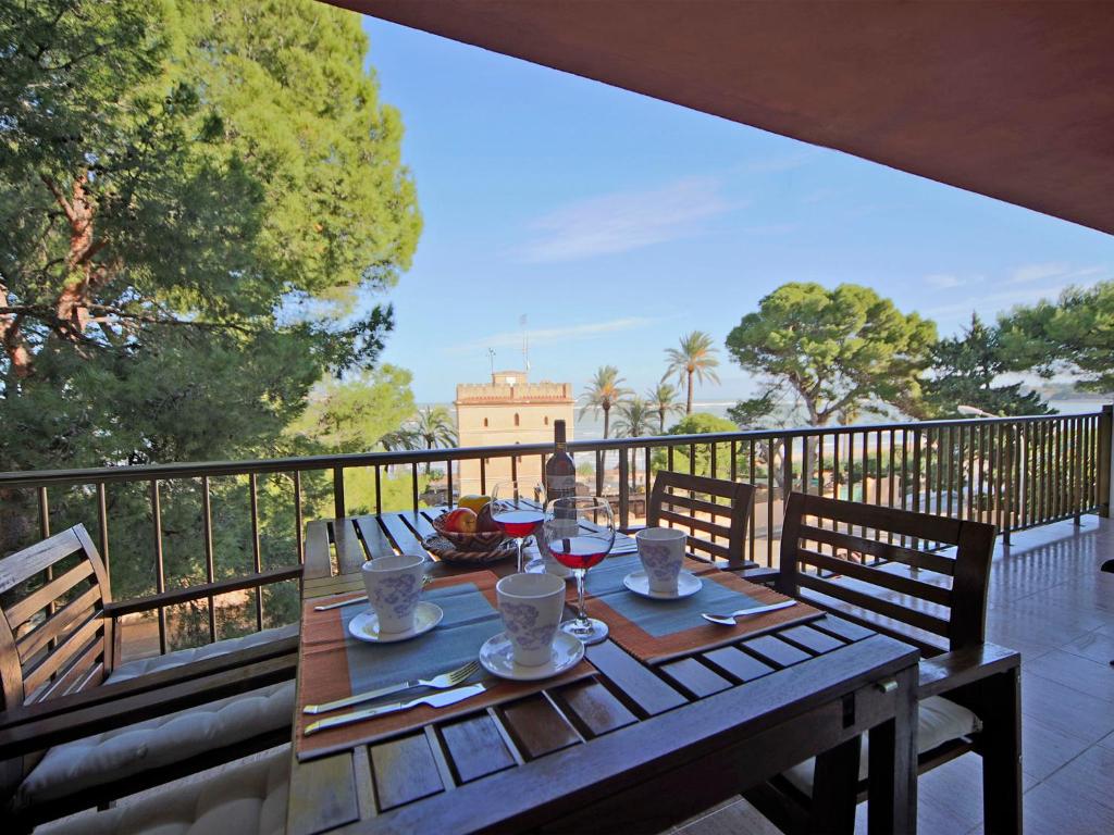 a wooden table with glasses of wine on a balcony at Apartment Sorts de la Mar-1 by Interhome in Denia