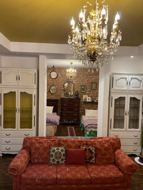 salon z kanapą i żyrandolem w obiekcie Apartment Nesti in Pristina Kosovo w Prisztinie