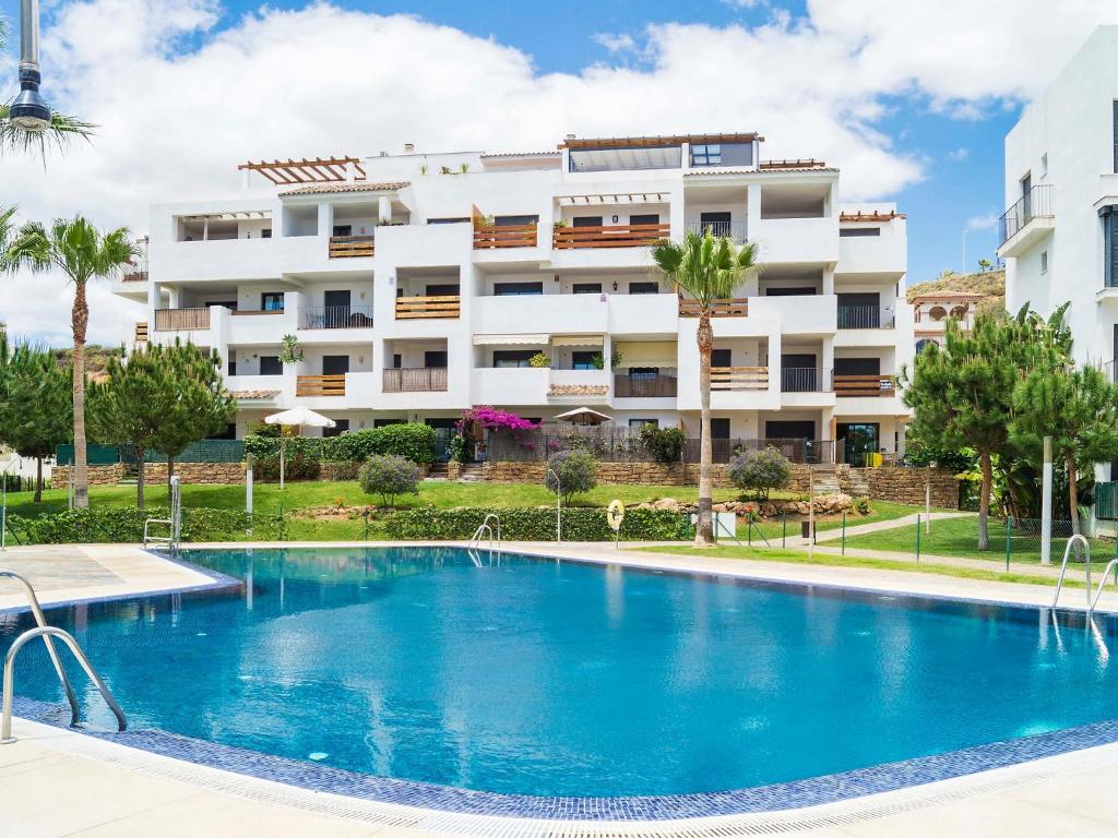 a hotel with a swimming pool in front of a building at Apartment Alamar by Interhome in La Cala de Mijas