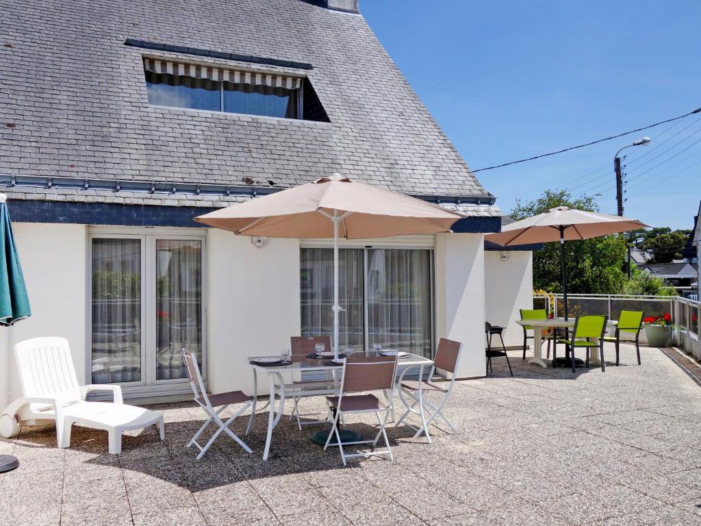 a patio with a table and chairs and umbrellas at Apartment Les Embruns-2 by Interhome in Carnac