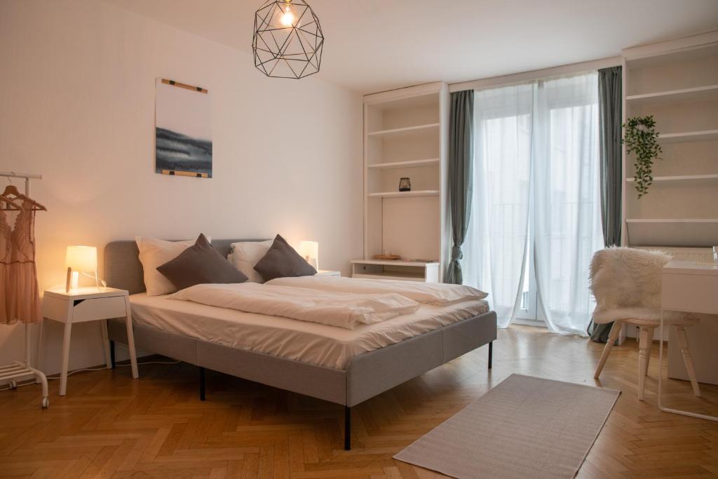 a bedroom with a bed and a large window at 2 BR City Apartment in Neubau, 6 min to city center in Vienna